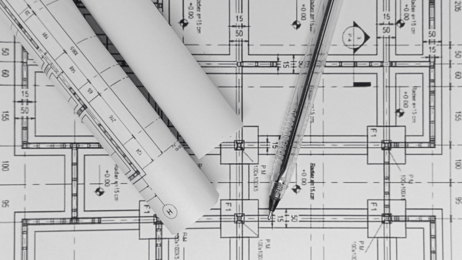 Architectuur bouwtekeningen met rolled plannen en liniaal voor constructie ontwerp
